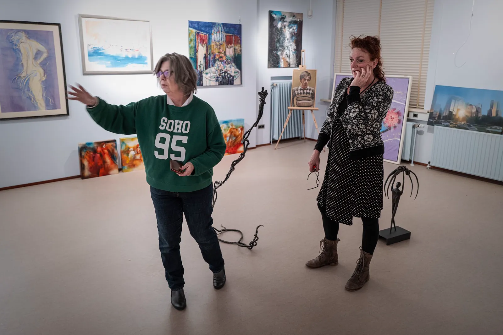 Herma Grimmius en Nynke Gardenier in de bovenzaal van De Groninger Zilverkamer, tussen schilderijen en beelden voor de expositie